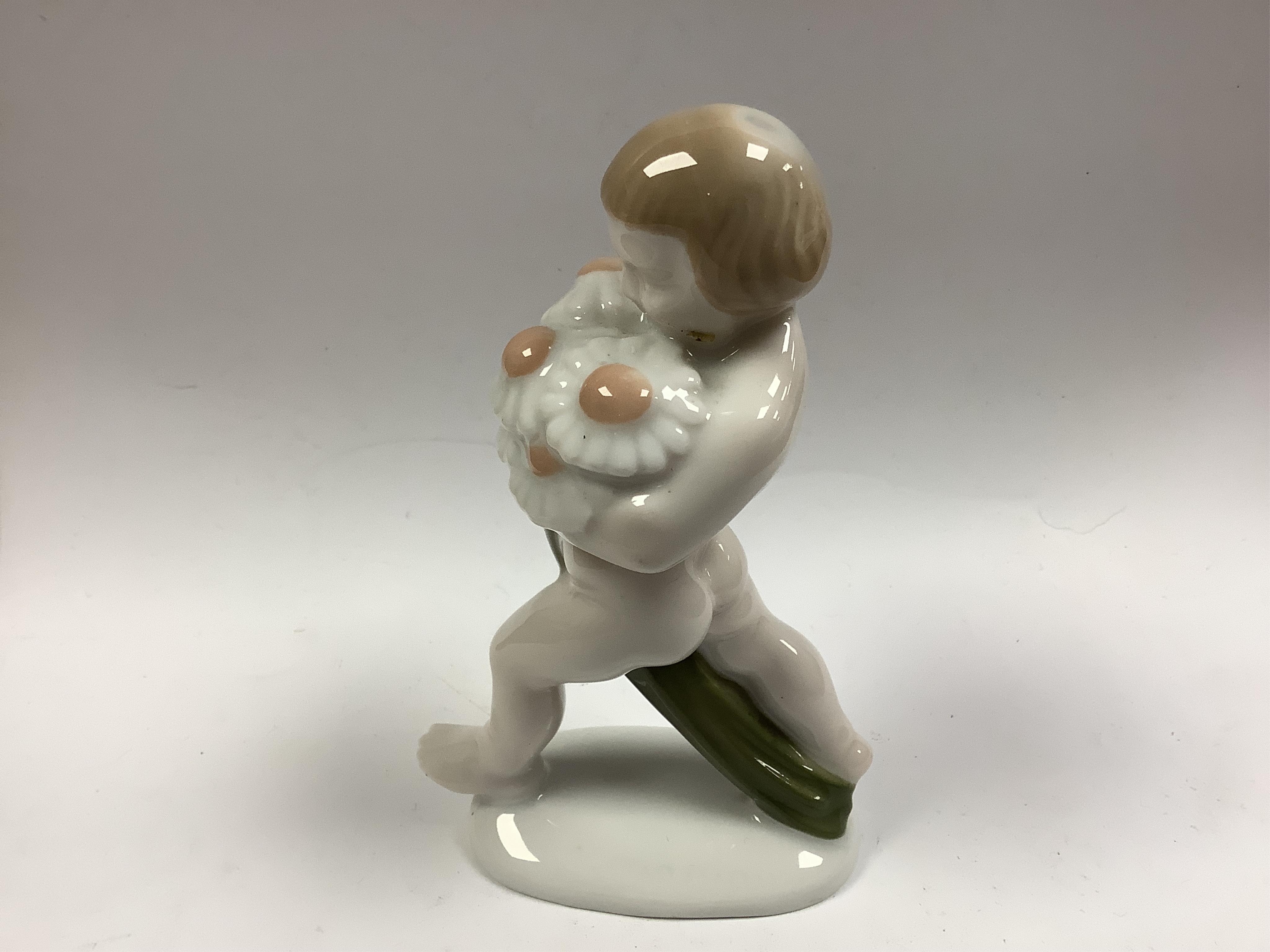 A Rosenthal Selb Bavaria putto with flowers, modelled by A. Caasmann, c.1923, 11cm high, PLEASE NOTE NO PORSGRUND DISH IN THIS LOT. Condition - good